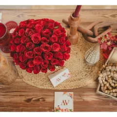 A top-down view of a table centerpiece. We layer textures and elements like custom stationery, floral arrangements, and traditional beads to make every detail feel intentional.