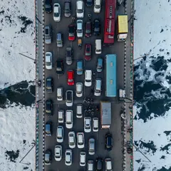 From above, the infamous Delhi traffic transforms into a work of art. This top-down aerial photo captures the chaotic yet colorful pattern of cars on a bridge over the Yamuna, finding a moment of organized beauty in the city's constant motion.
