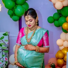 A quiet moment of reflection for the mother-to-be amidst the party. Her hand on her bump, she is the serene center of the celebration.
