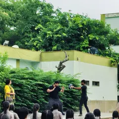 Demonstrating basic striking techniques to school girls. Teaching them how to use their fists and elbows effectively is a core part of building their confidence and defensive capability.
