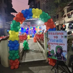 A vibrant balloon arch and a personalized welcome sign create an exciting entrance for a Super Mario themed first birthday party.