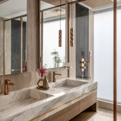 We believe bathrooms should be private sanctuaries. Here, we used exquisite white marble for the integrated double sink, paired with warm wood cabinetry and rose gold fixtures. Details like the backlit mirror and frosted glass shower partition create a spa-like atmosphere that is both functional and serene.