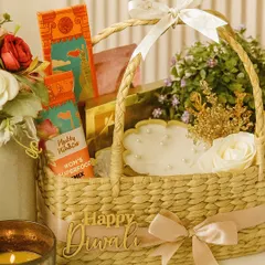 Our Utsav Basket is a beautiful blend of tradition and elegance. It features a natural cane basket filled with Phool incense, a lotus urli candle, a festive lantern, and a mix of sweet and savory treats, all adorned with a "Happy Diwali" tag.