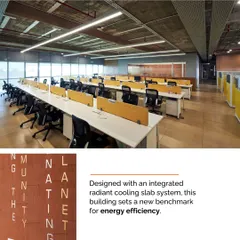 The open-plan office at Mahindra Chakan is designed with an integrated radiant cooling slab system, a benchmark for energy efficiency. The raw concrete ceiling and industrial aesthetic are balanced by views of the surrounding landscape.