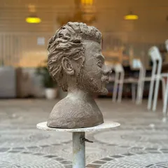 A side profile of a sculpted bust, capturing the likeness and emotion of the subject with remarkable detail.