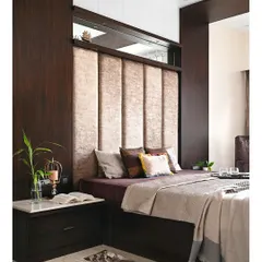 Another angle of the master bed, showing how the dark veneer paneling wraps around the headboard to create a cohesive, built-in look. The marble-topped side table adds a touch of classic elegance to the modern design.