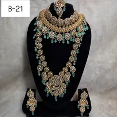 This modern layered set, code B-21, is a favorite among brides. It combines a statement choker with a matching long haar, featuring beautiful mint green beads for a fresh and contemporary look.
