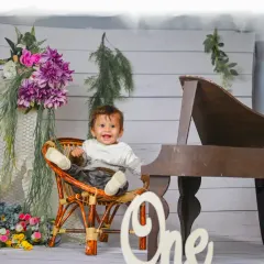 Celebrating ONE! This elegant setup with a miniature piano and floral details is a beautiful way to mark a first birthday.