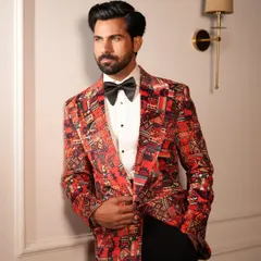 The Cantaloupe Tuxedo jacket, shown here with a hand in pocket, exudes a relaxed confidence. The rich colors and geometric patterns make it a perfect centerpiece for a cocktail or reception outfit.