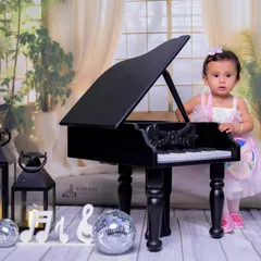 Our 'Mini Musician' theme is perfect for little princesses too. Dressed in a lovely pink gown, she looks right at home next to the piano, surrounded by elegant props like lanterns and a disco ball.