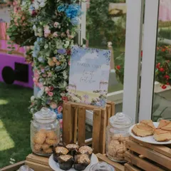 The 'Love at First Bite' bakery cart, set against a beautiful floral arch. We believe that food presentation is a key part of the guest experience.