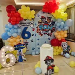 A fun and colorful Paw Patrol theme for a 6th birthday. The decoration features a large backdrop with the whole pup squad, character cutouts, and a marquee number '6'.