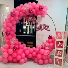 This is an "It's a Girl" announcement and welcome home setup. I used a half-moon balloon arch made entirely of pink balloons, with "BABY" display boxes and foil letters to celebrate the new arrival.
