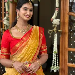 A client looking beautiful in a traditional red and yellow half saree. I designed the simple red blouse to perfectly complement the checks and borders of the skirt and dupatta.