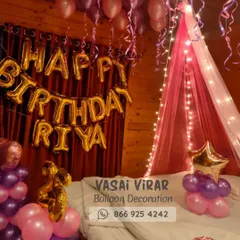 We love creating romantic surprises! This bedroom decoration features a dreamy pink canopy with fairy lights over the bed, surrounded by pink and purple balloons. The personalized "Happy Birthday Riya" foil balloons make the celebration feel extra special.