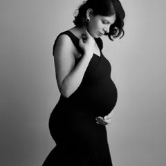 The grace of motherhood captured in a classic black and white profile. The elegant lines of her dress and the gentle curve of her bump create a truly timeless image.