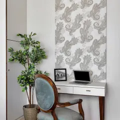 Your 9-to-5 just scored some serious style points. This chic home office corner features a classic wooden desk and a velvet-upholstered chair, set against a beautiful paisley wallpaper for an artistic touch.