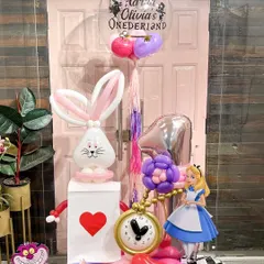 A full view of the Alice in "Onederland" setup, complete with a personalized bubble balloon. Every element is carefully placed to tell a story and create a picture-perfect moment for a special celebration.