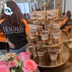 A stunning three-tiered stand filled with individual Tiramisu cups, a classic Italian dessert perfect for large gatherings.
