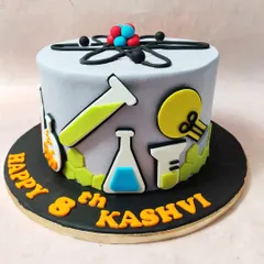 A side view of our chemistry cake, showing the variety of lab equipment and molecular structures.