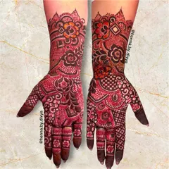 This dense bridal mehendi is a beautiful mix of floral motifs and geometric patterns like checkerboards, creating a rich and textured look that covers the hands and forearms.