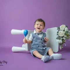 A burst of laughter from this well-dressed toddler. I love capturing these candid moments of pure joy during my classic portrait sessions.