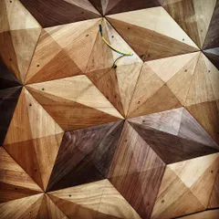 A close-up of a 3D geometric wood panel, showing the precise cutting and arrangement of different wood veneers. This kind of detail adds incredible texture and depth to a surface.