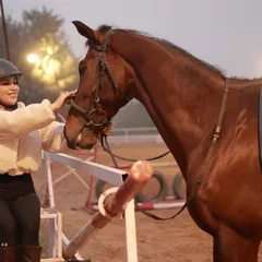 A rider takes a moment to connect with her horse before a ride. Our facility is a place where you can find peace and build a unique friendship.