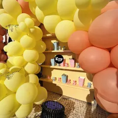 A detail shot of the built-in shelving within our "Sweet as Can Bee" backdrop. The shelves are framed by yellow and peach organic balloons and are perfect for displaying party favors or small decorative items that match the theme.