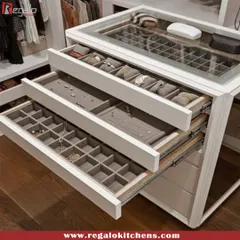 This custom island features tiered drawers with glass tops and specialized compartments for jewelry and watches, turning your accessory collection into a stunning display.