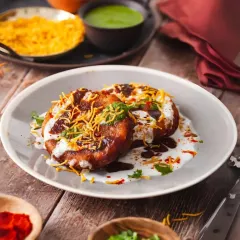 A true classic, my Aloo Tikki Chaat is a flavour explosion. It features a perfectly crisp potato patty, creamy yogurt, tangy tamarind chutney, and a sprinkle of fresh coriander and crunchy sev.