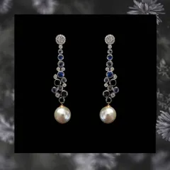 A cascade of blue sapphires and diamonds leads down to a large south sea pearl drop in these elegant long earrings. The color contrast makes them a truly captivating accessory.