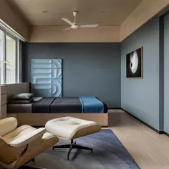 In the son's bedroom of 'A Hint of Azul', a long console runs the length of the window and transforms seamlessly into the bed's headboard. This custom furniture piece unifies the long, cuboidal space.