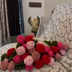 A close-up look at the "bouquet" part of the blanket. I used various shades of pink and red yarn to create these 32 crochet roses, giving the border a lush, three-dimensional look.