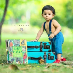 A playful portrait of a curious toddler. I often use props like these colorful vintage suitcases and classic books to engage children and bring out their natural charm during a shoot.