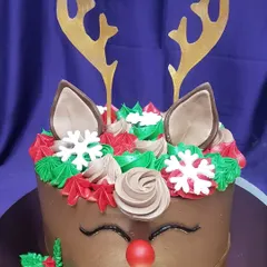 Get into the festive spirit with this adorable reindeer cake. The chocolate cake is decorated with buttercream swirls, edible antlers, and a cute red nose, making it a perfect treat for a Christmas party.