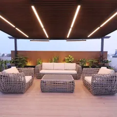 A modern wicker furniture set under a large pergola with linear lighting at our completed Gurgaon project.