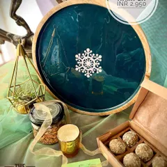 For this hamper, we chose an elegant round platter with a deep teal finish, perfect for serving treats during festive get-togethers. It comes with our favorite upcycled sweets and an air plant in a geometric brass holder, adding a modern touch to your decor. It’s a complete festive starter kit in a box.