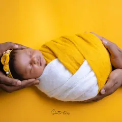 This 'parents' hands' pose is a beautiful way to show connection. The shot, inspired by a mango-vanilla ice cream, uses a yellow and white wrap for a vibrant, warm feel.