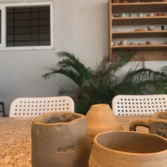A collection of raw, unfired pieces on my studio table. One of them has the word "HOPE" stamped into it, a small reminder of the emotions I pour into my work.