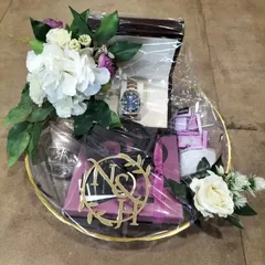 We handle high-value items with the utmost care. This gift platter for the groom features a luxury watch, elegantly packaged with floral accents and a custom laser-cut monogram of the couple's initials for a truly personal touch.