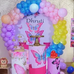 A vibrant butterfly theme with a custom backdrop and themed pedestals, perfect for a colorful celebration.