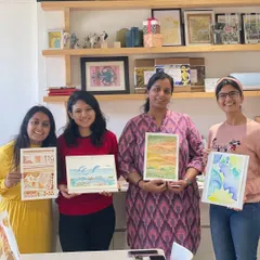 Four participants showing off their beautiful watercolor creations from a weekend workshop.