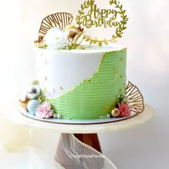 This is my take on the modern fault line cake trend. I used a combination of textured green and smooth white buttercream, highlighted with edible gold leaf for an elegant touch. It's a Choco Raspberry cake, perfect for a sophisticated birthday celebration.