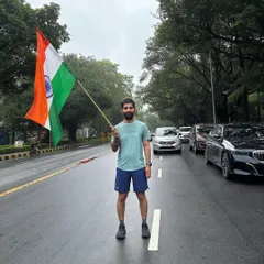 A runner holding the flag high on a Delhi road. We run with the spirit of India in our hearts.