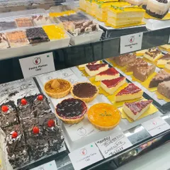 A close-up of one of our display cases, showcasing an array of tarts, cheesecakes, and pastries. It's the perfect spot for a cute date or a fun hangout.