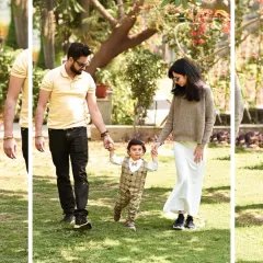 A candid moment of parents holding their son's hands as he takes his first steps on the grass. Outdoor sessions are perfect for capturing these active milestones.