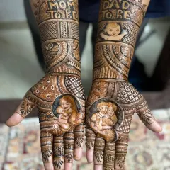 Celebrating the journey to parenthood with this detailed baby shower mehendi. The palms feature sweet portraits of the mother and father holding their baby, surrounded by traditional patterns.