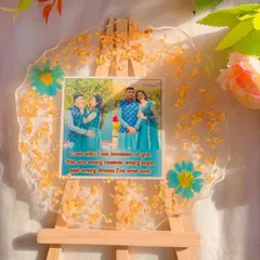 Simplicity can be so powerful. This clear resin platter is decorated with just a sprinkle of gold leaf and a few pressed flowers, keeping the focus on the couple's photos and the lovely quote.