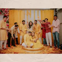 A joyous group photo from a Haldi ceremony, with friends and family showering the couple with flower petals. These are the candid, chaotic, and beautiful memories I love to capture.